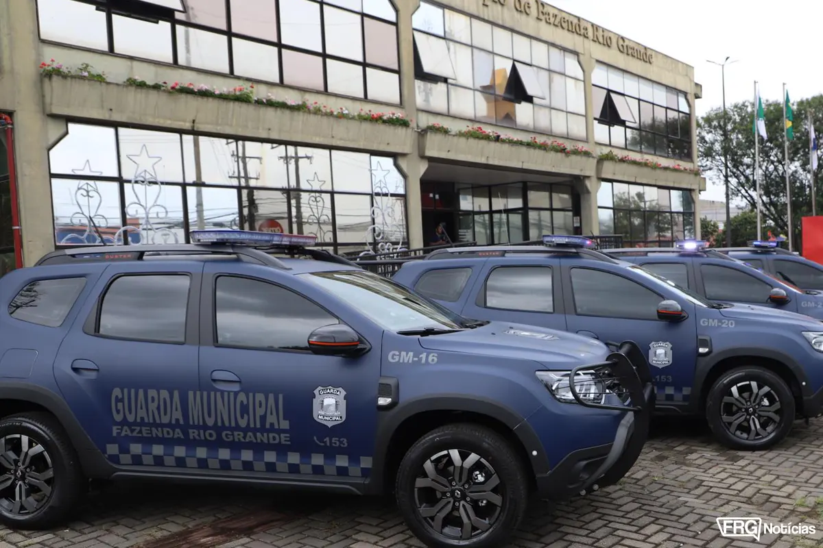Viaturas modernas da Guarda Municipal de Fazenda Rio Grande estacionadas em frente ao prédio da prefeitura. Os veículos azuis possuem identificação visual oficial e giroflex, representando o investimento em segurança pública na Região Metropolitana de Curitiba.
