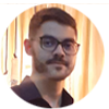 Fotografia em formato circular do jornalista Silvanei Alcantara, um homem jovem com óculos de armação escura, barba e bigode aparados, olhando para a câmera.